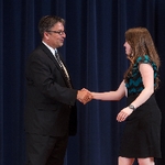 Doctor Smart shaking hands with an award recipient in a teal and black shirt
